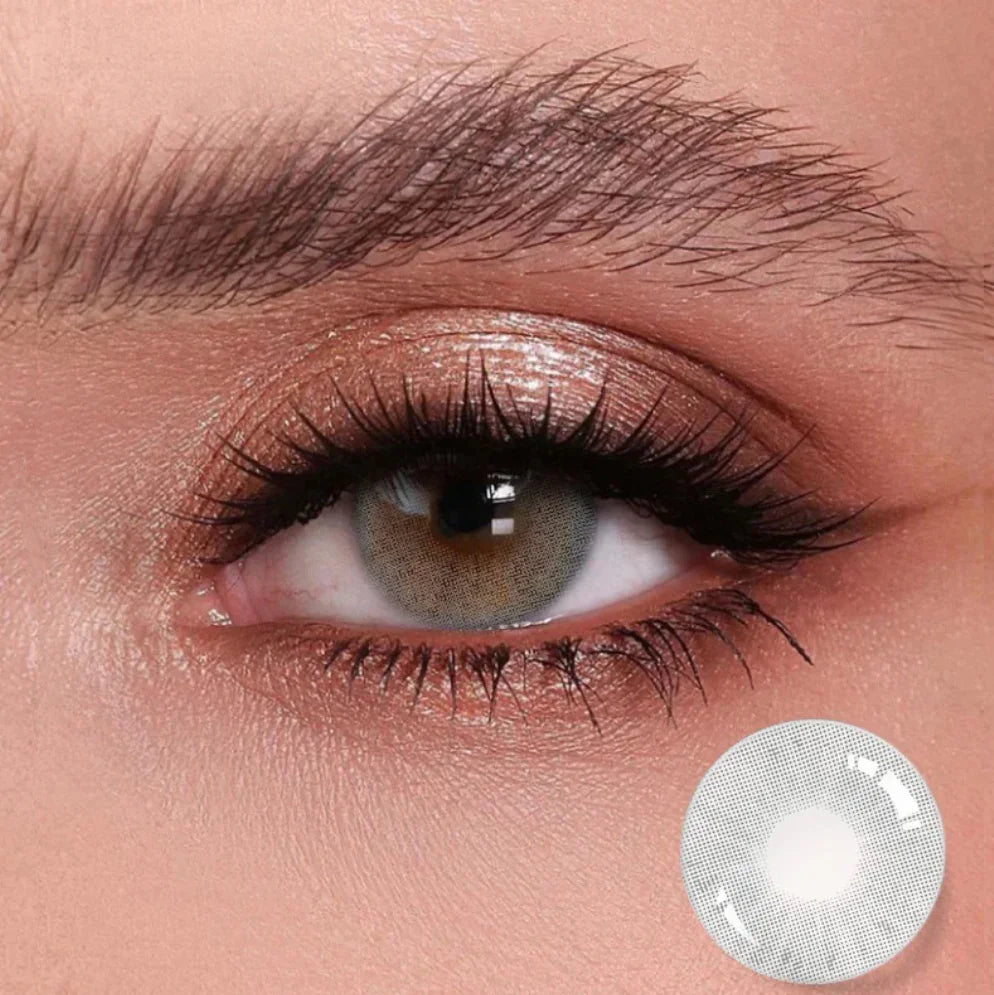 Gros plan d’un œil portant une lentille de couleur vert naturel avec reflet lumineux.